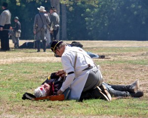 Doctors and nurses tend to the wounded, and carry off the dead on stretchers.